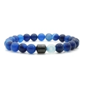 Macro detail of blue natural stone beads and silver hexagonal charm on the beaded bracelet - Blue Striped Agate