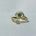 Macro detail of golden evil eye ring featuring blue crystals and sparkling white zircon - Adjustable Open / Gold