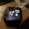 Eleganti orecchini a fiore d'oro con perle e cristalli su un portagioie in pelle vintage - Stile Perno in Argento Color Oro