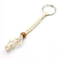 Detail view of handmade macrame key ring with beige cotton cord and natural wood bead detail - Off White