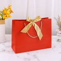 Elegant red gift paper bag with a golden ribbon bow and woven handles for packaging - 28*9*20cm / Red