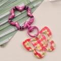 Detail of pink floral clasp and acrylic butterfly pendant with plaid texture for keychain - Red Grid Butterfly