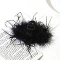 Top view of a fluffy black ostrich feather hair claw clip on an open vintage book page - 13cm Black Ostrich Feather Claw Clip