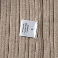 Detail of satin laundry label showing fabric composition on knitted rib dress - Beige (50% Viscose/30% Polyester/20% Nylon)