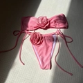 Detailed close-up of pink bandeau bikini featuring large 3D fabric rose decorations - Peach