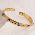 Dettaglio del bracciale a polsino placcato oro 18 carati con texture martellata e malocchio - Blu Reale