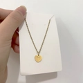 Dettaglio del ciondolo a cuore dorato con incisioni radiali su una catena sottile - DN106 Linea del Cuore