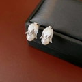 Gros plan macro de boucles d'oreilles fleurs argentées vintage avec perles blanches rondes - Argenté