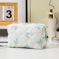Vista dettagliata di una borsa per cosmetici trapuntata bianca con fiocchi blu chiaro - 16*9*9cm / Base Bianca Fiocco Blu
