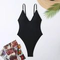 Detailed flat lay of black deep V-neck one-piece swimsuit with summer vacation accessories - Black