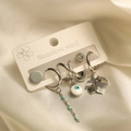 Detail of stainless steel earrings featuring evil eye and maple leaf charms in silver finish - Evil Eye Turquoise Set