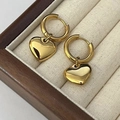 Gros plan sur des boucles d'oreilles cœur en or poli miroir dans un écrin à bijoux - Tout Or