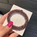 Detailed view of a purple beaded crystal hair tie on a white fashion jewelry display card - Purple