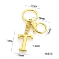 Golden metal keychain with letter T pendant and lobster clasp on white background - Letter T