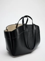 Dettaglio laterale di borsa tote in pelle nera con cuciture bianche e doppi manici - Nero