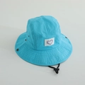 Dettaglio del cappello da sole blu lago con tesa larga, toppa a cuore e cordino regolabile - 52cm / Celeste