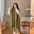 Olive green long scarf with soft fringe tassels in a warm indoor lifestyle setting - Matcha Green