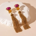 Detalle de pendientes vintage dorados con borlas y piedras púrpuras sobre base de piedra - Borla de cadena ovalada de color contrastante (pin de plata 925)