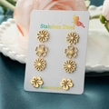 Elegantes Set aus vier Paar goldenen Edelstahl-Blumenohrsteckern auf einer Displaykarte - 4 Paare Set / Gold