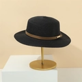 Detail of a black woven straw hat with brown leather band and gold buckle on a stand - M (56-58cm) / Black