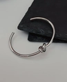 Detailaufnahme eines silbernen Knot-Armreifs auf einem dunklen Steinhintergrund - Silber