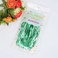 Close-up of a green foil fringe curtain in retail packaging for party decorations - 1*2m Green