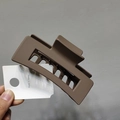 Close-up of a matte mocha rectangular hair claw clip held in hand with Korea tag - Matte Coffee