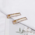 Elegante goldene Entenschnabel-Haarspangen mit funkelnden AB-Kristallen auf weißem Stoff - Farbverlauf