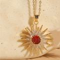 Collana a girasole dorata con zircone rosso centrale su espositore in pietra - Rosso Rubino