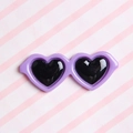 Macro shot of a purple heart-shaped resin accessory for DIY plush doll glasses - Purple