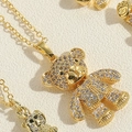 Macro detail of golden bear pendant necklace with full zircon pavé settings on fine chain - Movable Bear