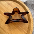 Macro detail of star-shaped hair claw clip with brown tortoiseshell pattern and metal spring - Matte Yellow Coffee Tortoise