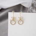 Elegant gold bow earrings with sparkling crystals and pearl on a white display card - Gold Bow Pearl Hoop Earrings (E3313)
