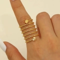 Makroaufnahme des goldenen Spiralrings mit doppelten Blumenakzenten an der Hand eines Modells - Mehrlagiger Spiralring (DZ-703) / Goldimitat