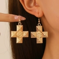 Detailed view of gold cross earrings with embossed swirl textures on a female model - Gold Earrings (Snail Texture 12033)