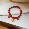 Vue macro du bracelet à perles rouges avec breloque cheval à bascule dorée élégante - Style Perle Facettée Cheval de Couleur et Perle Rouge (14#)