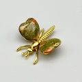 Broche de mariposa dorada con gemas a rayas verdes y rojas sobre fondo gris claro - Unakita / Dorado