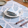 Blue geometric print napkin in cotton linen fabric on a white ceramic plate - Blue Barley Seedling