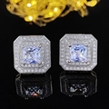Detailed close-up of princess cut blue zircon stud earrings with double halo on black mirror - Square White (E668)