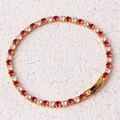 Detailed macro view of golden tennis bracelet with alternating red and clear round cubic zirconia - Rose Red Bracelet-Gold