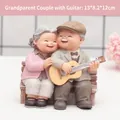 Statuine in resina di coppia anziana con nonno che suona la chitarra seduto su panca - 1041-9 Suonare la chitarra
