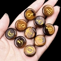 Tiger eye stone set of 10 engraved planet astrology symbols held in a palm - Tiger's Eye