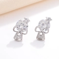 Macro shot of silver skull earrings with round cubic zirconia and star detail - Skull