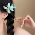 Detailaufnahme einer minzgrünen Blumen-Haarspange aus Stoff an einer eleganten Flechtfrisur - Blau