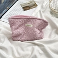 Detail of pink knitted pleat cosmetic bag with Suzakka label on soft white fabric - Light Pink