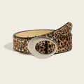 Gros plan sur une ceinture léopard avec boucle ovale argentée et rivets sur fond beige - Imprimé léopard