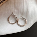 Detailed view of silver hoop earrings on soft white textured fabric with metallic luster - 25mm / Silver