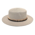 Gros plan d'un chapeau de paille à sommet plat avec ruban noir et chaîne en métal doré - M (56-58cm) / Gris clair