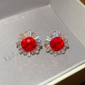 Macro shot of sunburst stud earring with red cushion-cut stone and square zircon - Gold-Red