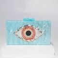 Detalle de bolso de mano de acrílico marmoleado con ojo de la suerte brillante en soporte - Azul claro